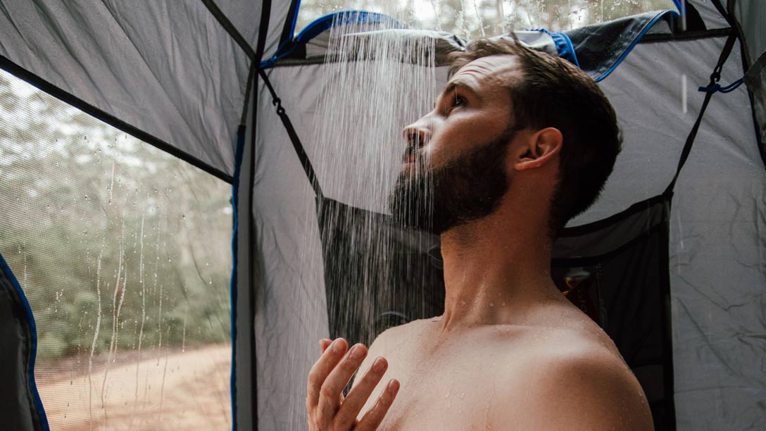 Man showering inside a shower tent