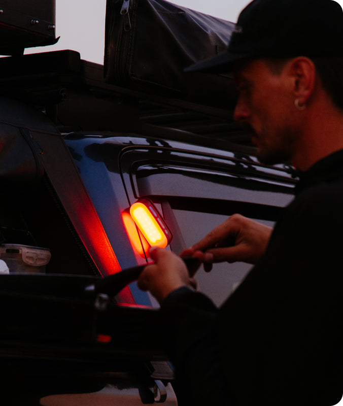 Person working on a vehicle's tail light