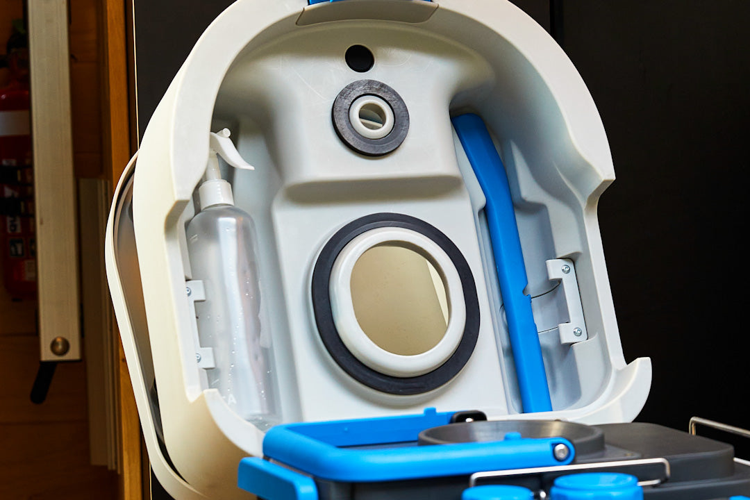 Inside the open GottaGo lid, showing the spray bottle and blue poker tool stored in place