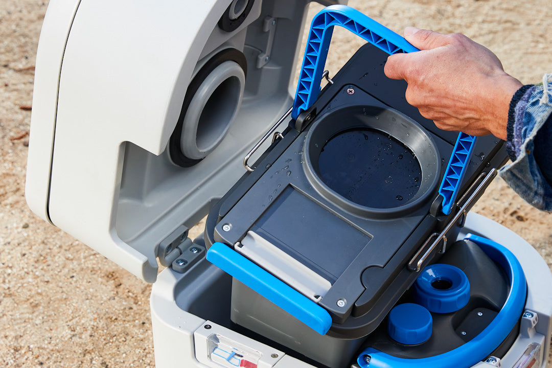 Hand lifting the swappable solids cassette out of an open GottaGo by its blue handle