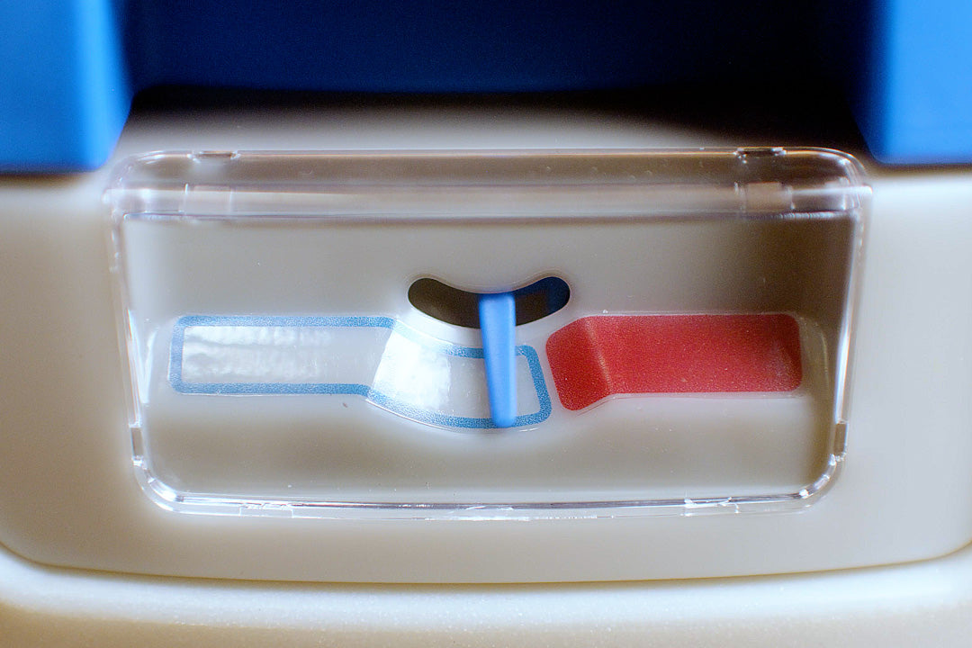 Close-up of the GottaGo urine level indicator window, with a blue pointer between the empty and full marks